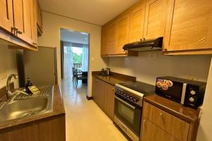 a kitchen with a sink and a stove at Crosswinds Swiss Deluxe Suite in Tagaytay