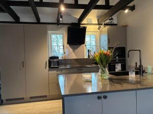 a kitchen with a vase of flowers on a counter at Kanalhuset in Tvååker
