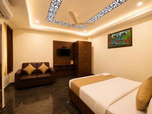 a hotel room with a bed and a chair at Hotel Hyfa Continental in Lucknow