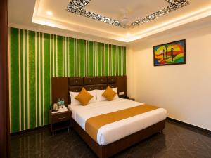 a bedroom with a large bed with a green curtain at Hotel Hyfa Continental in Lucknow
