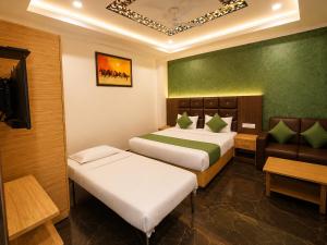 a hotel room with two beds and a couch at Hotel Hyfa Continental in Lucknow +29 photos