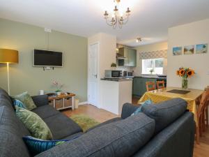 a living room with a couch and a kitchen at 14 The Dell in Norwich