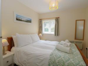 a bedroom with a white bed and a window at 14 The Dell in Norwich