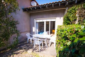 a white table and chairs on a patio at Appartements Les Déferlantes Mimizan-plage in Mimizan-Plage