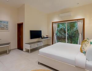 a bedroom with a bed and a flat screen tv at Lamrin Morjim Goa in Morjim