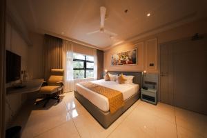 a hotel room with a bed and a desk and a window at Hanric by Eight Continents Amaranta, Varkala in Varkala