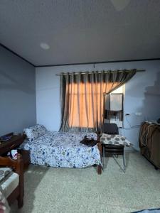 a bedroom with a bed and a table and a window at Traveler rest in Arbājīyah