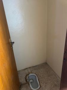 a small bathroom with a toilet in the floor at Traveler rest in Arbājīyah