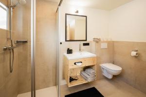 a bathroom with a toilet and a sink and a shower at Grillhofer - Slow Living Apartments -LUNGAUCard inkludiert in Mauterndorf +145 photos
