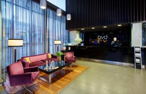 a lobby with two chairs and a table in a building at Sercotel Boulevard Vitoria-Gasteiz in Vitoria-Gasteiz