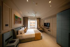 a hotel room with a bed and a television at Hanric by Eight Continents Amaranta, Varkala in Varkala