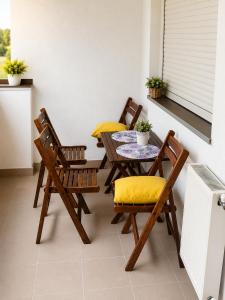 a table and chairs with yellow cushions on a balcony at Lux apartman Ub II in Ub