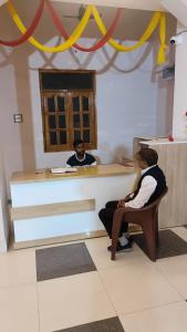two people sitting at a counter in a room at Divine Blessings Banquet and Hotel in Prayagraj