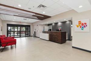 an office lobby with a red chair and a counter at Hampton Inn & Suites Houston Rosenberg in Rosenberg +48 photos