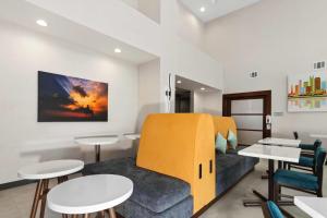 a room with a couch and some tables and chairs at Hampton Inn & Suites Houston Rosenberg in Rosenberg
