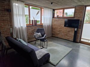 a living room with a couch and a chair at Chalet Buron 7 in Kaufbeuren