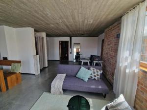 a living room with a purple couch and a brick wall at Chalet Buron 7 in Kaufbeuren