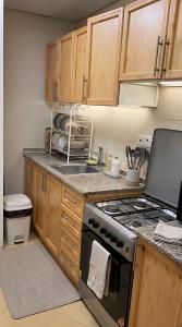 a kitchen with wooden cabinets and a stove top oven at Cozy Beyond Simple in Abu Dhabi