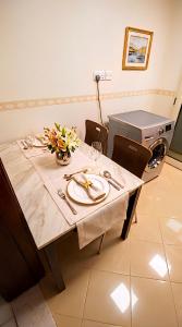 a dining table with a white table cloth and flowers on it at Cozy Beyond Simple in Abu Dhabi
