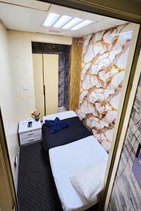 a small room with a bed and a stone wall at Cozy Beyond Simple in Abu Dhabi +5 photos