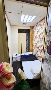 a small room with a bed and a rock wall at Cozy Beyond Simple in Abu Dhabi
