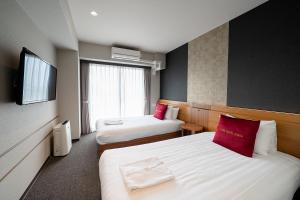 ein Hotelzimmer mit zwei Betten und einem Fernseher in der Unterkunft Five Hotel Osaka in Osaka + 68 Fotos