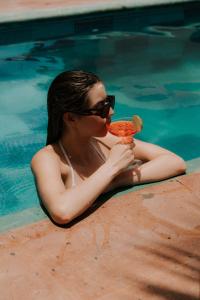 a woman in a swimming pool eating a slice of pizza at Montero Residences in Brisas de Zicatela