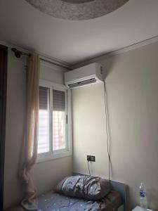 ein Schlafzimmer mit einer Klimaanlage an der Wand neben einem Fenster in der Unterkunft lot24 in Saidia  + 2 Fotos