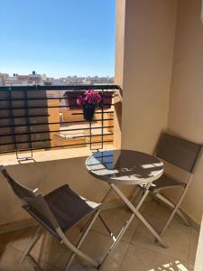 ein Tisch und zwei Stühle auf einem Balkon in der Unterkunft lot24 in Saidia 