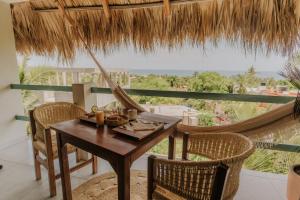 a table and chairs on a balcony with a hammock at Montero Residences in Brisas de Zicatela