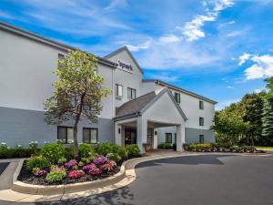 a white building with flowers in a driveway at Spark By Hilton Ann Arbor South in Ann Arbor