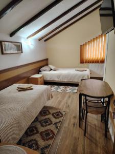 a room with two beds and a table and a chair at Casa Alma in Paşcani