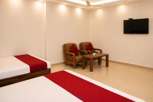 a bedroom with a bed and two chairs and a tv at Hotel Jayaditya Palace in Ayodhya