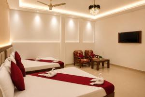 a bedroom with two beds with stuffed animals on them at Hotel Jayaditya Palace in Ayodhya +17 photos