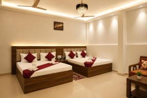 a bedroom with two beds and a couch at Hotel Jayaditya Palace in Ayodhya