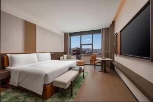a hotel room with a large bed and a flat screen tv at Wyndham Garden Datong Ancient City in Datong