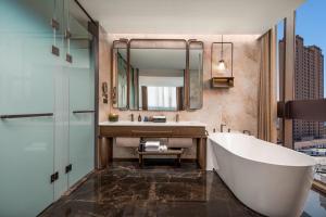 a bathroom with a tub and a sink and a mirror at Wyndham Garden Datong Ancient City in Datong +13 photos