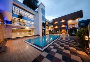 a swimming pool in the middle of a building at Hanric by Eight Continents Amaranta, Varkala in Varkala +17 photos