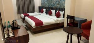 a bedroom with a bed and a table and a chair at Hotel Asian Palace in Guwahati +7 photos