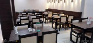 a dining room with black tables and chairs at Hotel Asian Palace in Guwahati