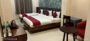a bedroom with a bed and a table and a chair at Hotel Asian Palace in Guwahati