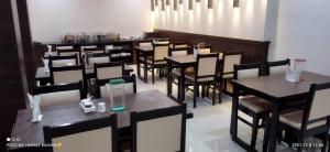 a dining room with black tables and chairs at Hotel Asian Palace in Guwahati