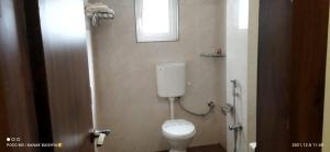 a bathroom with a white toilet and a window at Hotel Asian Palace in Guwahati