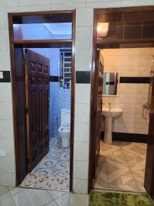 a bathroom with a toilet and a sink at Rippon Nest in Jinja