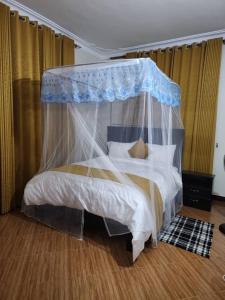 a bedroom with a bed with a canopy at Rippon Nest in Jinja