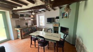 a kitchen and dining room with a table and chairs at Verde Salvia House in Corniglio