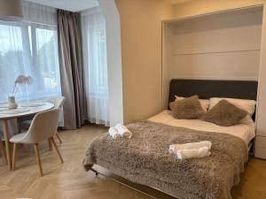 a bedroom with a bed with two stuffed animals on it at Cozy city centre apartment in Telšiai