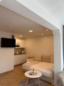 a living room with a bed and a table at Cozy city centre apartment in Telšiai
