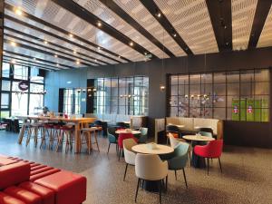 a restaurant with tables and chairs and a bar at Ibis Haiyan Economic Development Zone in Haiyan +51 photos