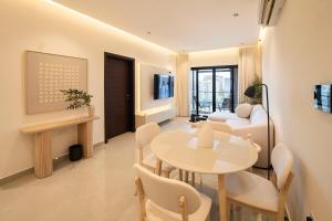 a living room with a table and a couch at Beige Apartment by Bait Zain - Bousher in Muscat